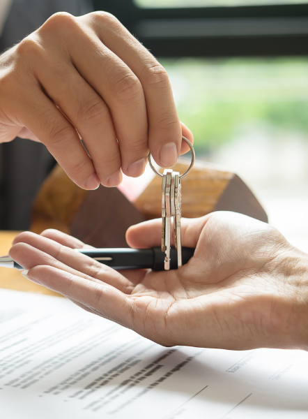 Gestor inmobiliario entregándole las llaves de su nueva vivienda a un cliente